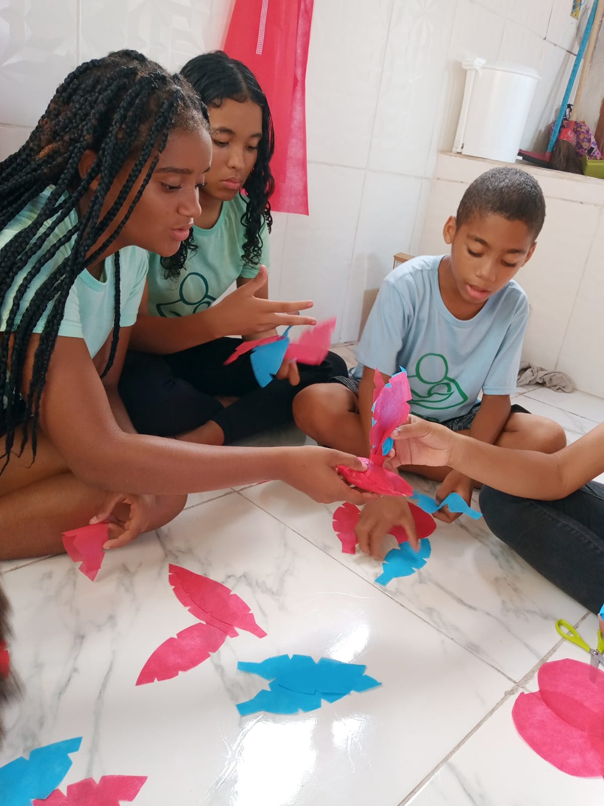 Adolescentes criando borboletas com papel colorido