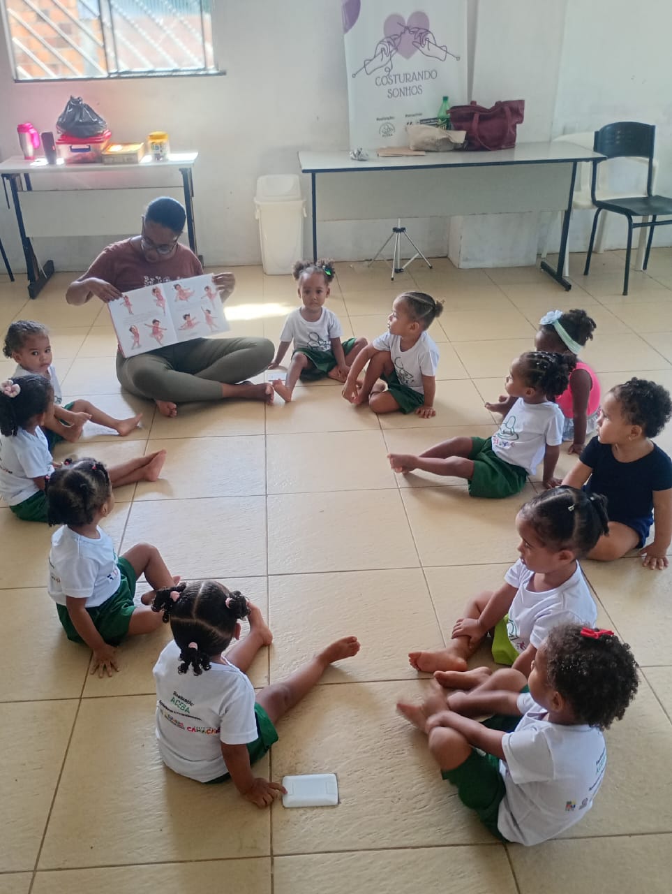 Educadora contando história para bebês