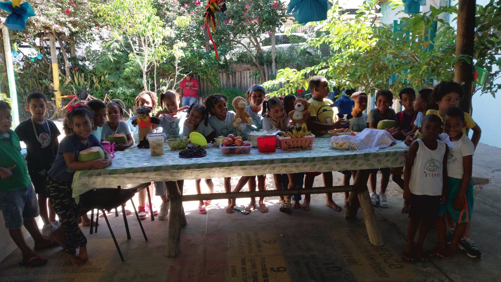 Crianças em volta da mesa de frutas