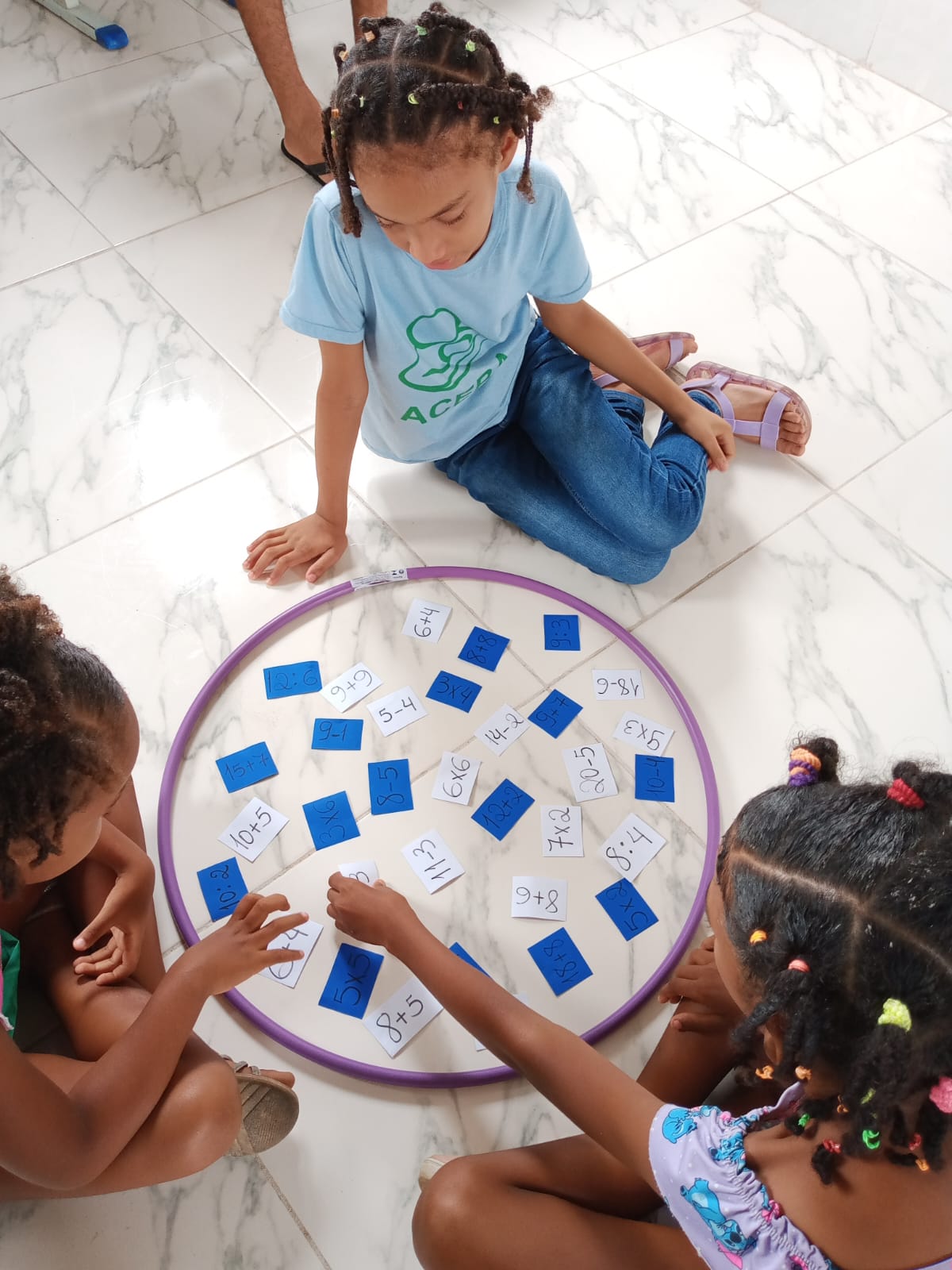 Meninas jogando matemática com bambolê