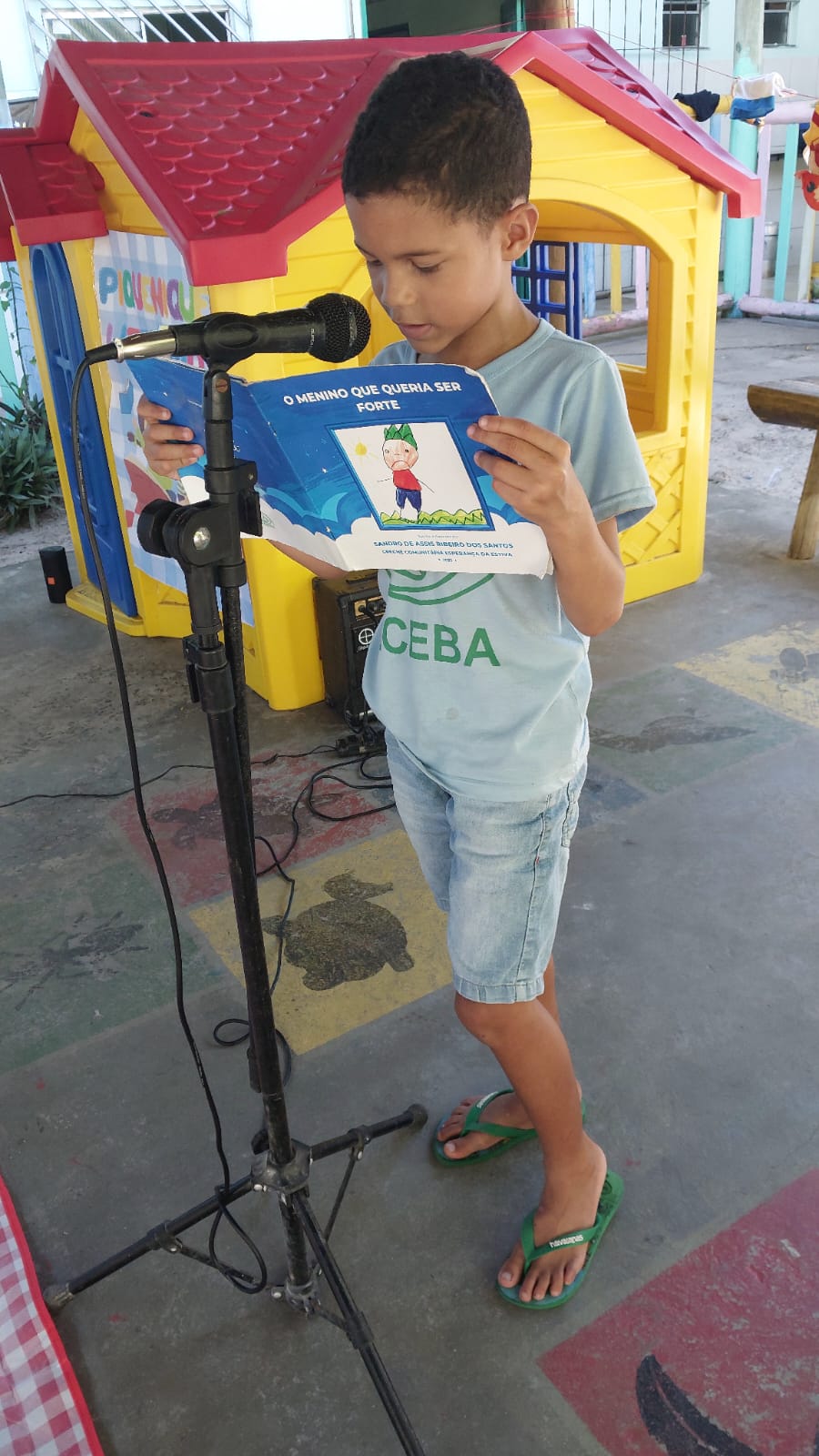 Criança lendo livro no microfone